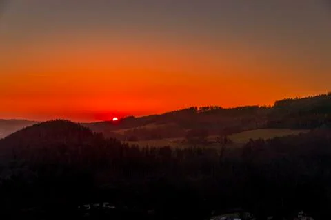 Close up sunset timelapse when sun is behind hills and mountains full of tree Stock-Fotos