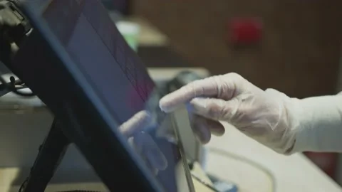 Close up of supermarket worker in protective gloves presses finger on computer Stock Footage 131190874