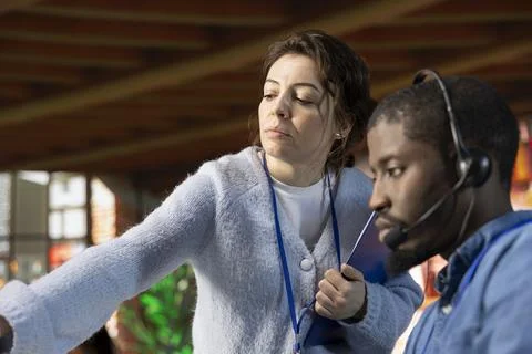 Close up of supervisor in customer support department office teaching intern Foto stock