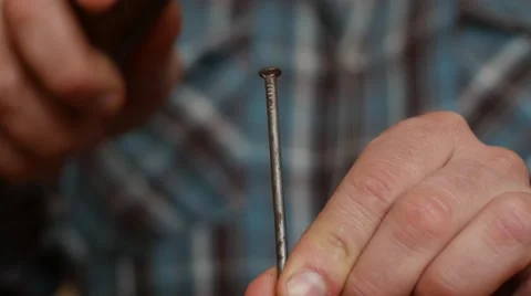 Close up of supported by hands big old nail hammering Stock Footage 48248152