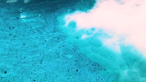 Close up surface of blue water on textured floor with smoke and bubbles in pool Stock Footage 315376639