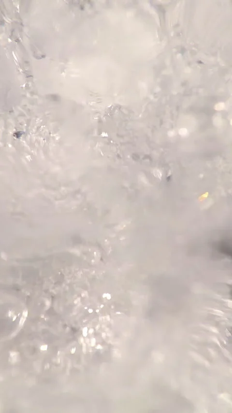 Close to surface over bubbling water flow under waterfall, slow motion, Extreme Stock Footage 311569966