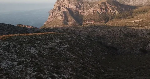 Close-up of the surface of rocky mountains on the ocean from a bird's-eye view Stock Footage 130170094