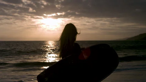 Close up of a Surfer Looking out Towards the Ocean at Sunset with a Surfboard Stock-Footage 270293853