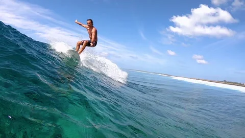 CLOSE UP: Surfer riding a wave splashes glassy ocean water into the camera. Stock Footage 131193356