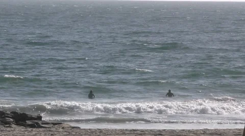 Close up of Surfers in waves and guy walking his dogs on beach Stock Footage 67617279