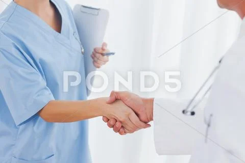 Close up on surgeon and doctor shaking hands Stock Photos