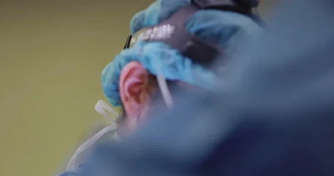 Close Up of Surgeon operating with eyeglasses mask &amp; surgery head lamp Stock Footage 146631360