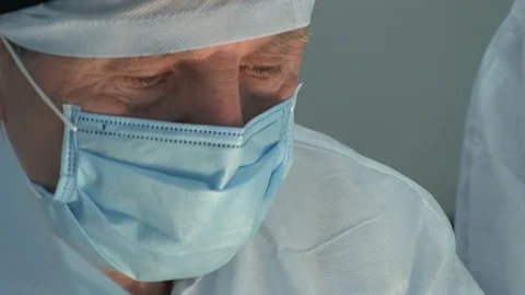 Close-up of a surgeon in the operating room. Doctors face during surgery. Stock Footage 125584276