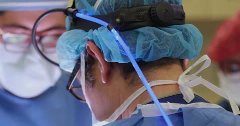 Close Up of Surgeons operating with eyeglasses and surgery head lamp Stock Footage 146641939