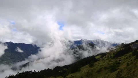 Close up of  the surging, churning sea of clouds above green mountain.4K Stock Footage 258762205