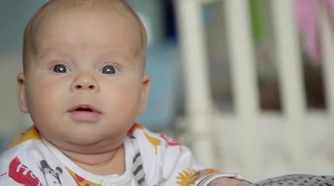 Close up of surprised baby's  face in the bedroom. Stock Footage 61676524