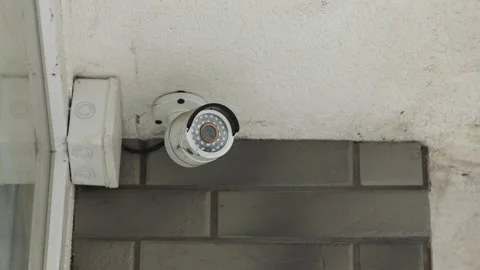 Close-up of a surveillance camera mounted on the facade of a building shop. Stock Footage 240285101