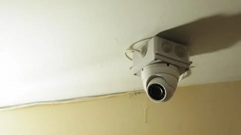 Close-up of a surveillance cctv camera mounted on the ceiling a building. The Stock Footage 240284889