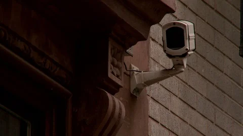 Close up of survelliance camera facing building entrance, day. Vídeo Stock 110810670