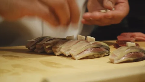 Close-up of a sushi chef preparing sushi for customers Видео 96239811