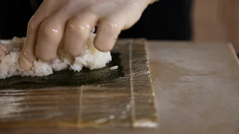 Close-up of sushi master spreads rice on nori.Sushi making process.Chef's hands Stock Footage 119559732