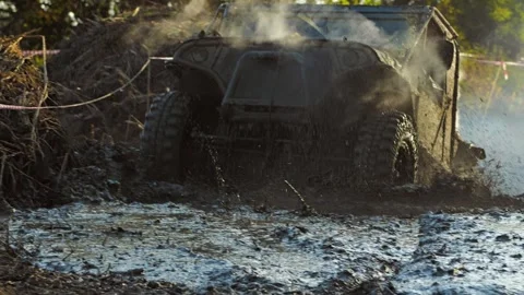 A close-up of an SUV driving through a muddy puddle Stock Footage 345495969