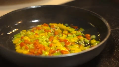 Close up of sweating motion chopped onions and red and green bell peppers with Stock Footage 263326631