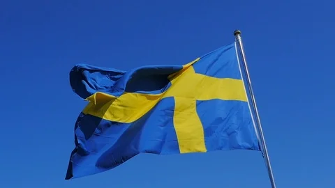 Close-up of the Swedish flag in slow-motion on a clear sunny day. The Stock Footage