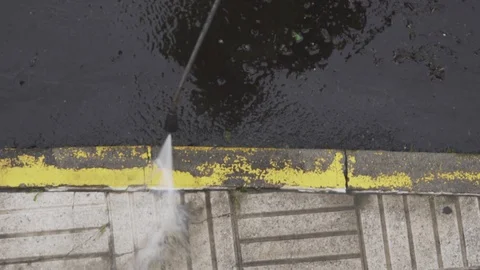 Close up of a sweeper cleaning a sidewalk with pressurized water jet Stock-Footage 128809680