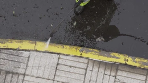 Close up of a sweeper cleaning a sidewalk with pressurized water jet Stock Footage 128809707