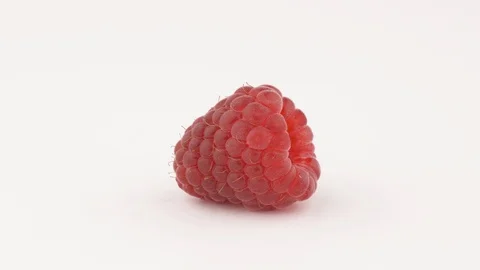 A close-up of sweet juicy raspberry rotating on white background, isolated. Stock Footage 112945899