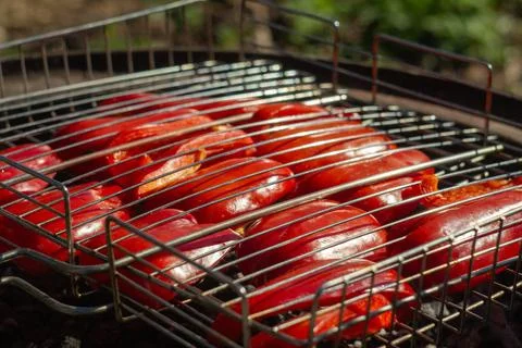 Close-up of sweet red pepper grilling in a mesh grill over barbecue 库存照片
