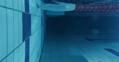 Close up of swimmer bouncing of pool wall while swimming in swimming pool Stock Footage 124676738