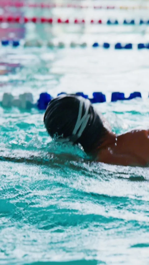 Close-up of swimmer's arm slicing through turquoise water during stroke Stock Footage 346458240