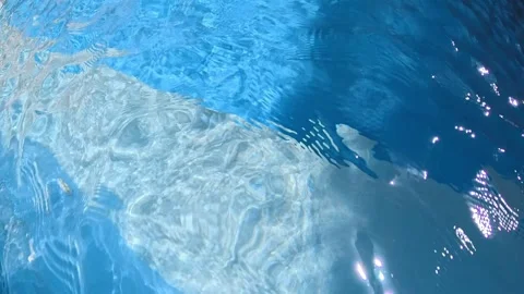 Close-up of a swimming pool water surface with shimmering reflections, blue Vidéo 333654257