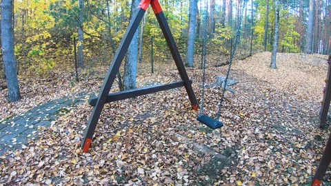 Close up swing in autumn, Abandoned empty swings swaying in the wind at children Stock Footage 111856728