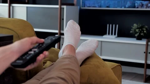 Close up of switching tv programs sitting on sofa using remote control. Stock Footage 141499490