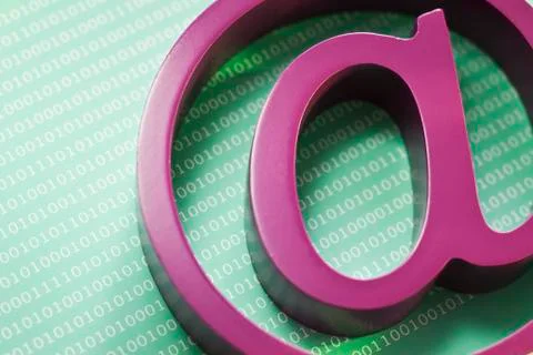 Close up of ?at? symbol and binary code 库存照片