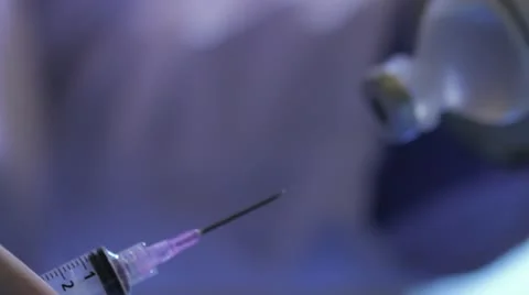 Close on syringe drawing from vial, transfer to bottle Stock Footage 20447579