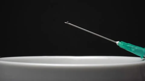 Close-up of syringe needle with drop isolated on black background. Water drop Stock Footage 85742275