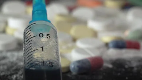 Close-up syringe plunger on the background of pills and medicines Stock Footage 263142002
