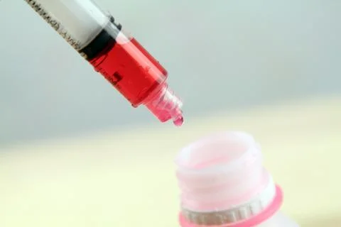 Close up syringe with red solution syrup. Medical Concept. Preparing medicine Stock Photos