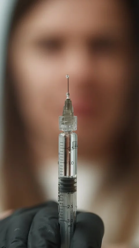 A close-up of a syringe from which liquid flows in the hands of a doctor Stock Footage 301519918