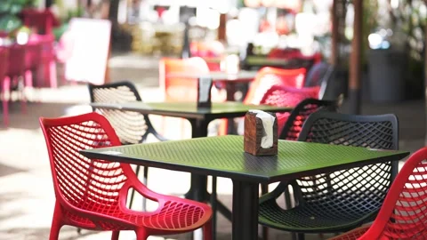 Close up of the table and chairs of an empty cafe in the summer morning. People Stock Footage 240646931