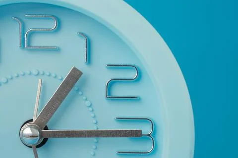 Close-up of a table clock isolated on a blue background, horizontal image Stock Photos