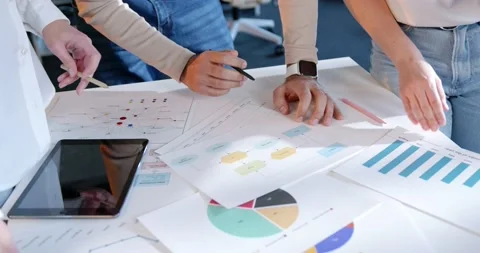 Close up of table with documents, charts and graphics. Male and females hands Stock Footage 180063134