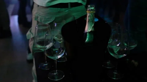 Close up of a table with glasses and a bottle of sparkling wine in a nightclub w Stock Footage 149003827