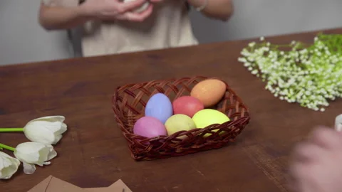 Close-up on a table with items to create a composition for Easter. Hands take Video stock 176440970