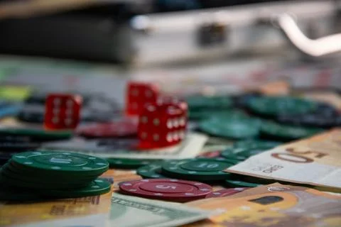 Close-up of a table with red dice, green poker chips, and Euro bills Stock Photos