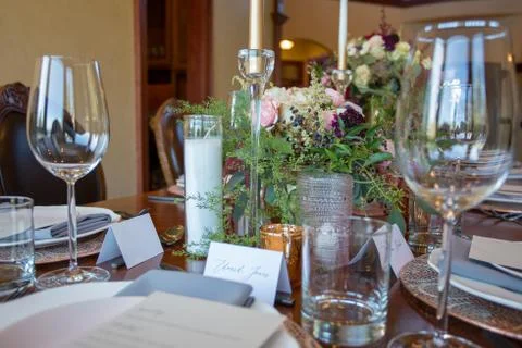 Close up of a table set decorated with fresh flowers and candles. Stock Photos