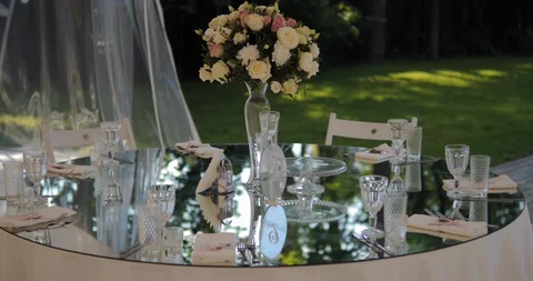 Close-up of a table set with glasses and flower arrangement.  Stock Footage 129999339