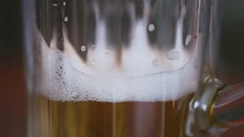Close up. On the table there is an empty glass in which pour beer with a foam is Stock Footage 84043896