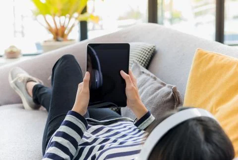 Close up on tablet computer blank screen with teenage girl enjoying listening Stock Photos