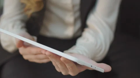 Close-up of tablet computer in female hands.In background,in soft focus,two Stock Footage 94241753
